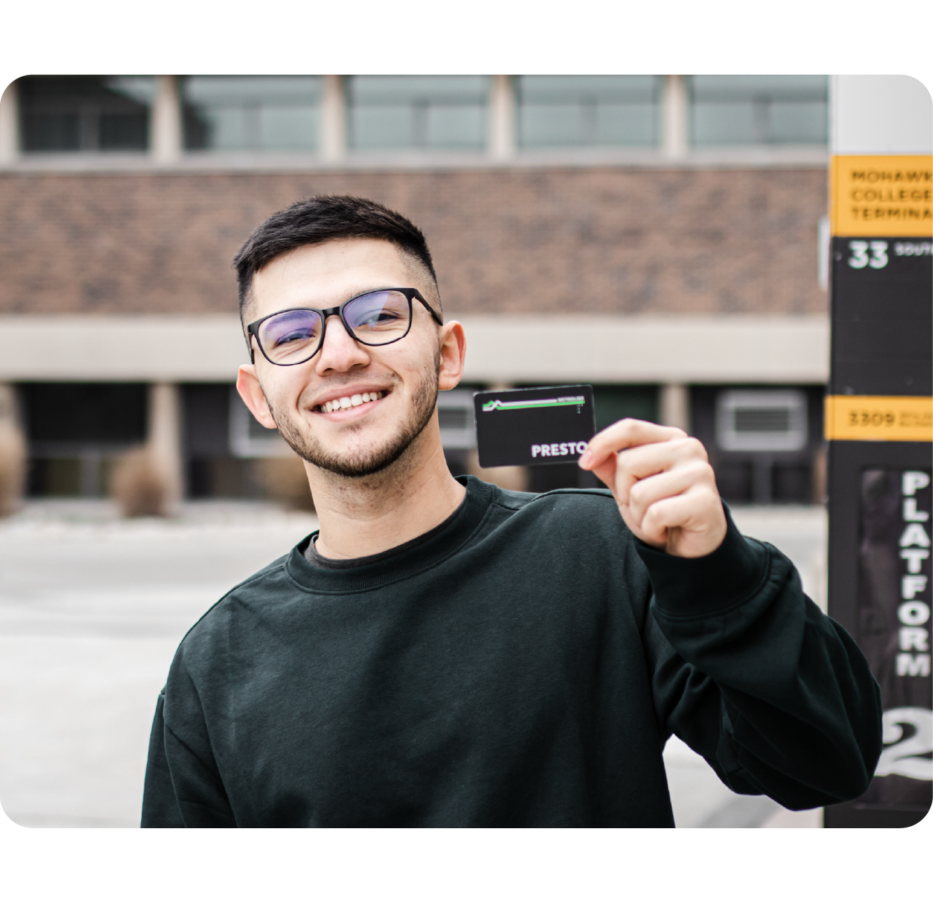 Person holding a PRESTO card and smiling
