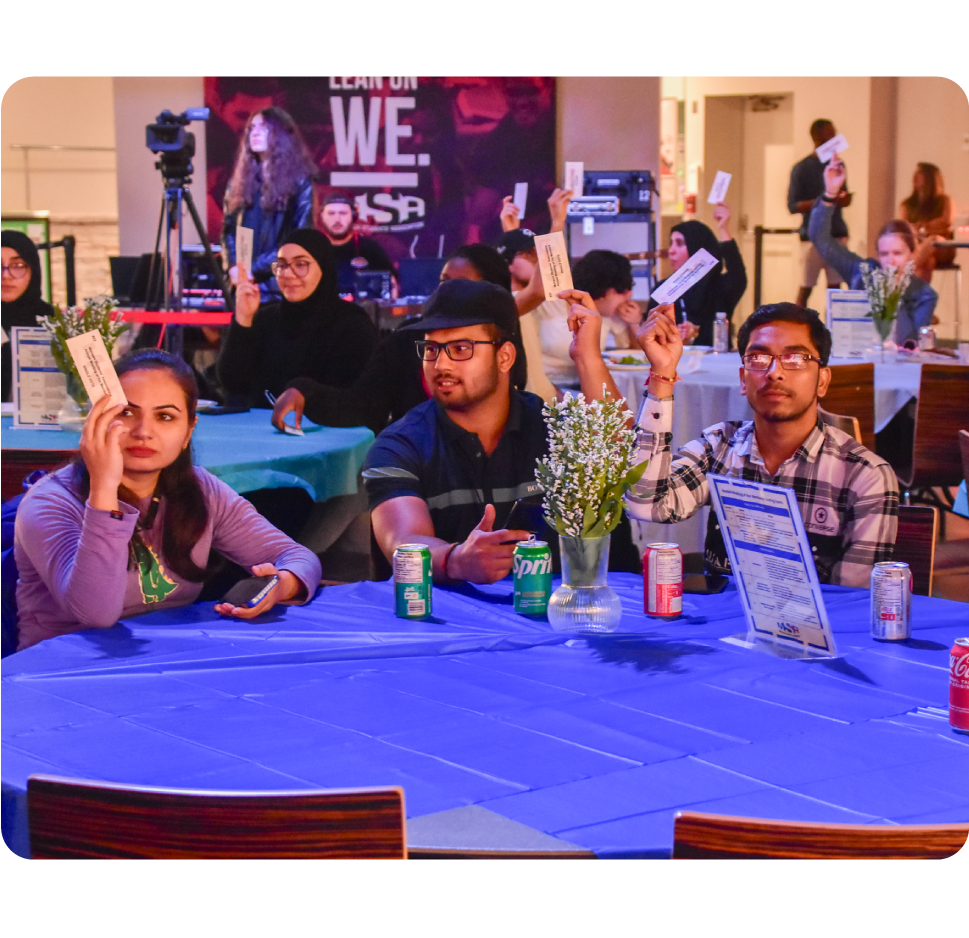 Students raising their voting cards at the Annual Meeting of the Members.