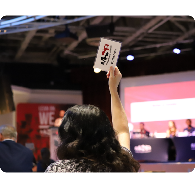 Student holding up their voter card at the Annual Meeting of the Members.