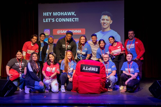 Sam Demma poses with MSA staff on stage in The Arnie (2023). 