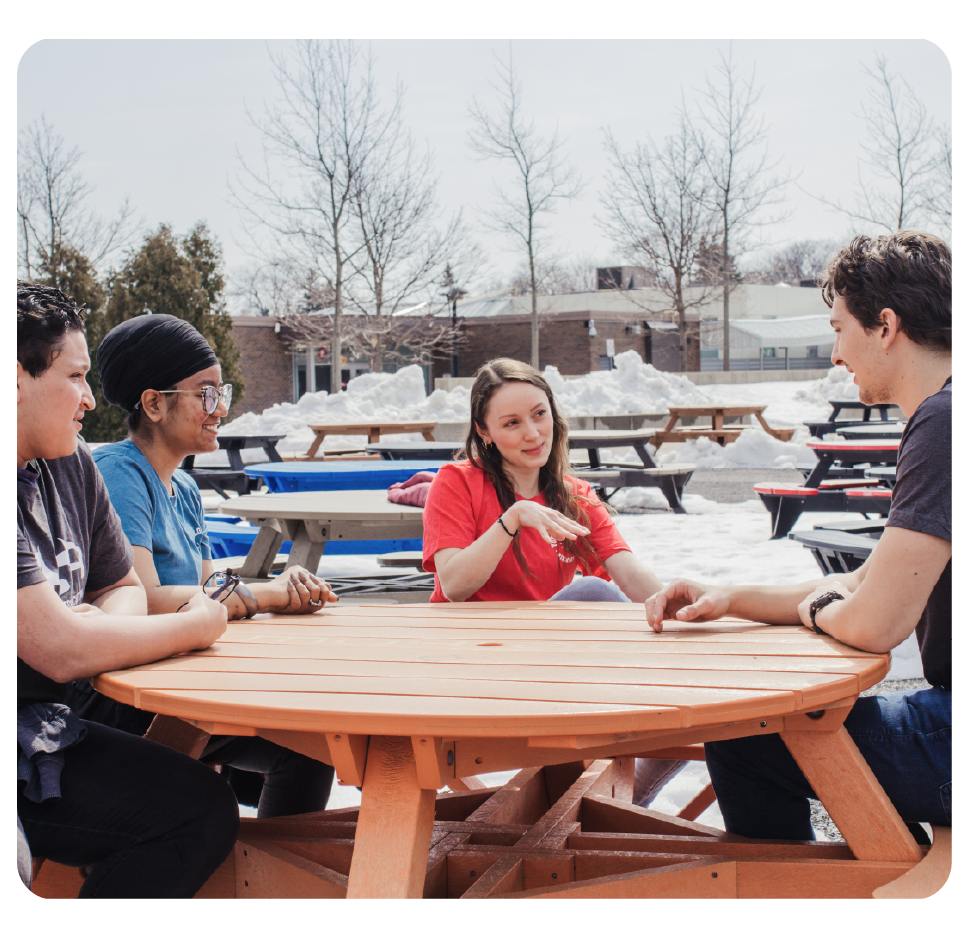 Students sitting around a table in the MSA Plaza.